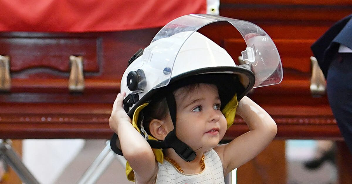 20-month-old wears Australian firefighter dad's helmet and refuses to leave his side at funeral