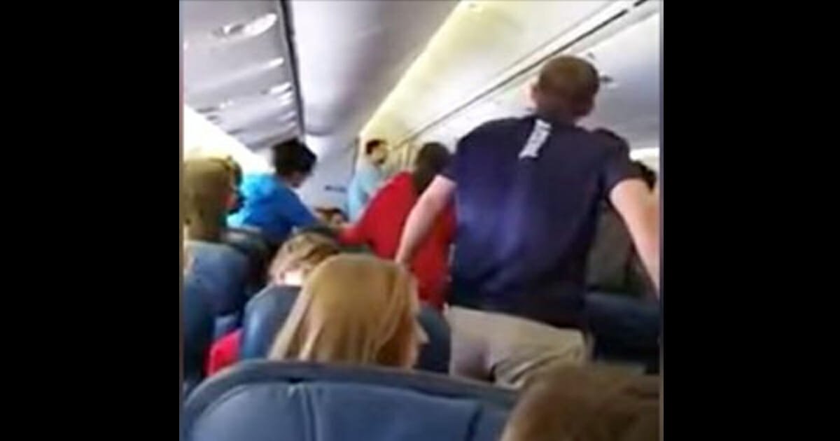 High school choir stand up to sing hymn as fallen U.S. soldier is carried off plane