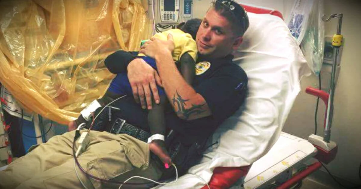 Photo of police officer snuggling abandoned toddler in hospital bed goes viral